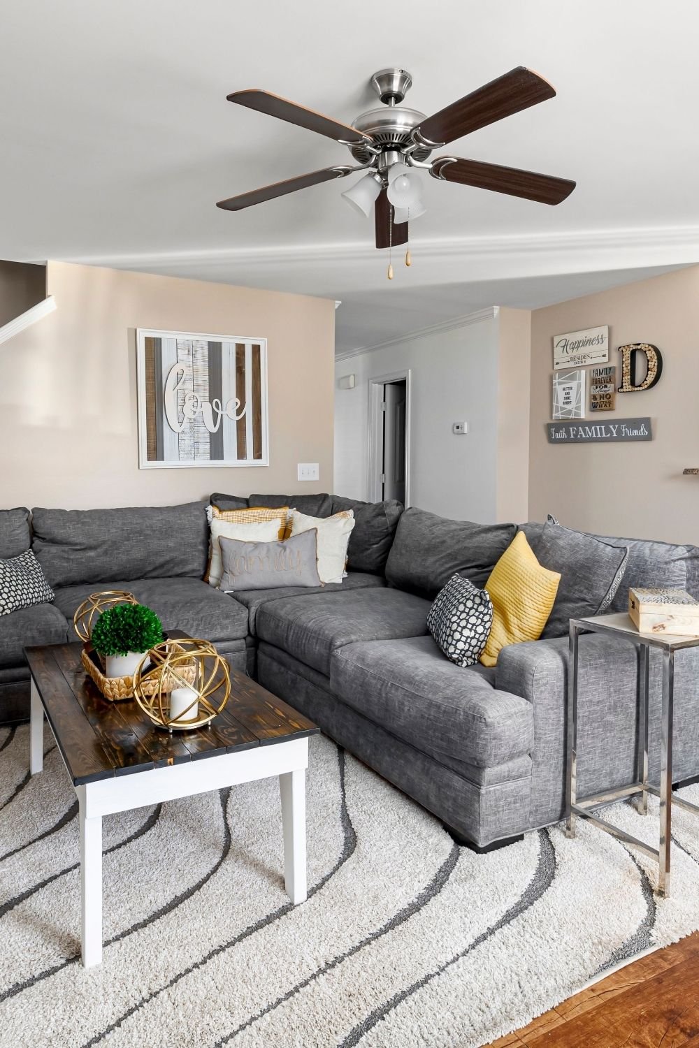Gray corner sectional with a rectangular coffee table on a wavy striped shag rug