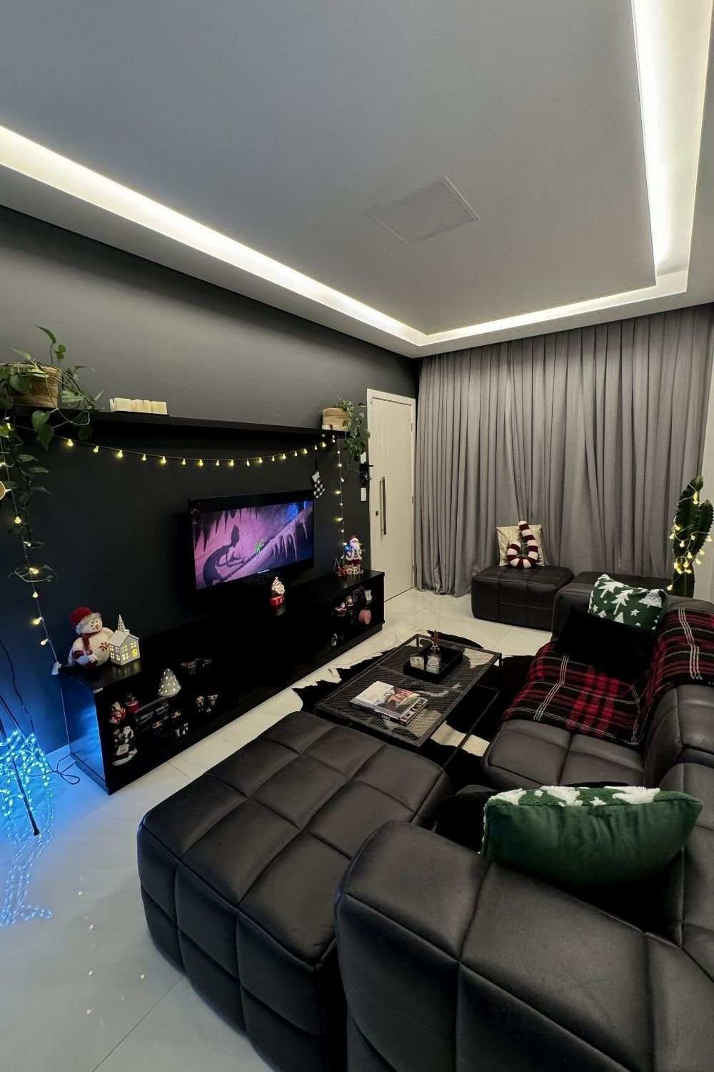 Compact living room with a charcoal TV wall decorated with string lights and holiday figures