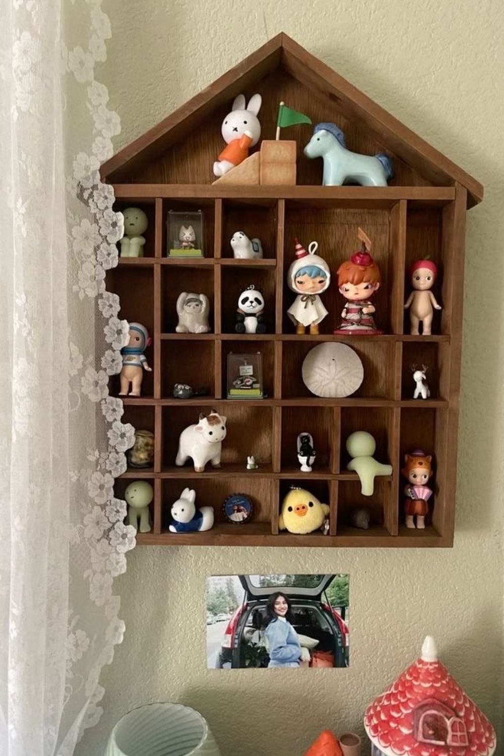 House-shaped wooden compartment shelf filled with small collectible figures, each in its own box
