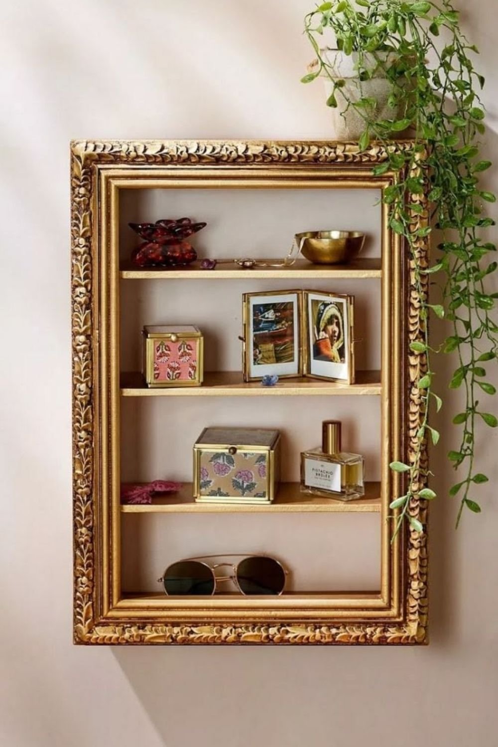 Ornate gilt picture frame fitted with four shelves and used to display jewelry, small boxes and perfume