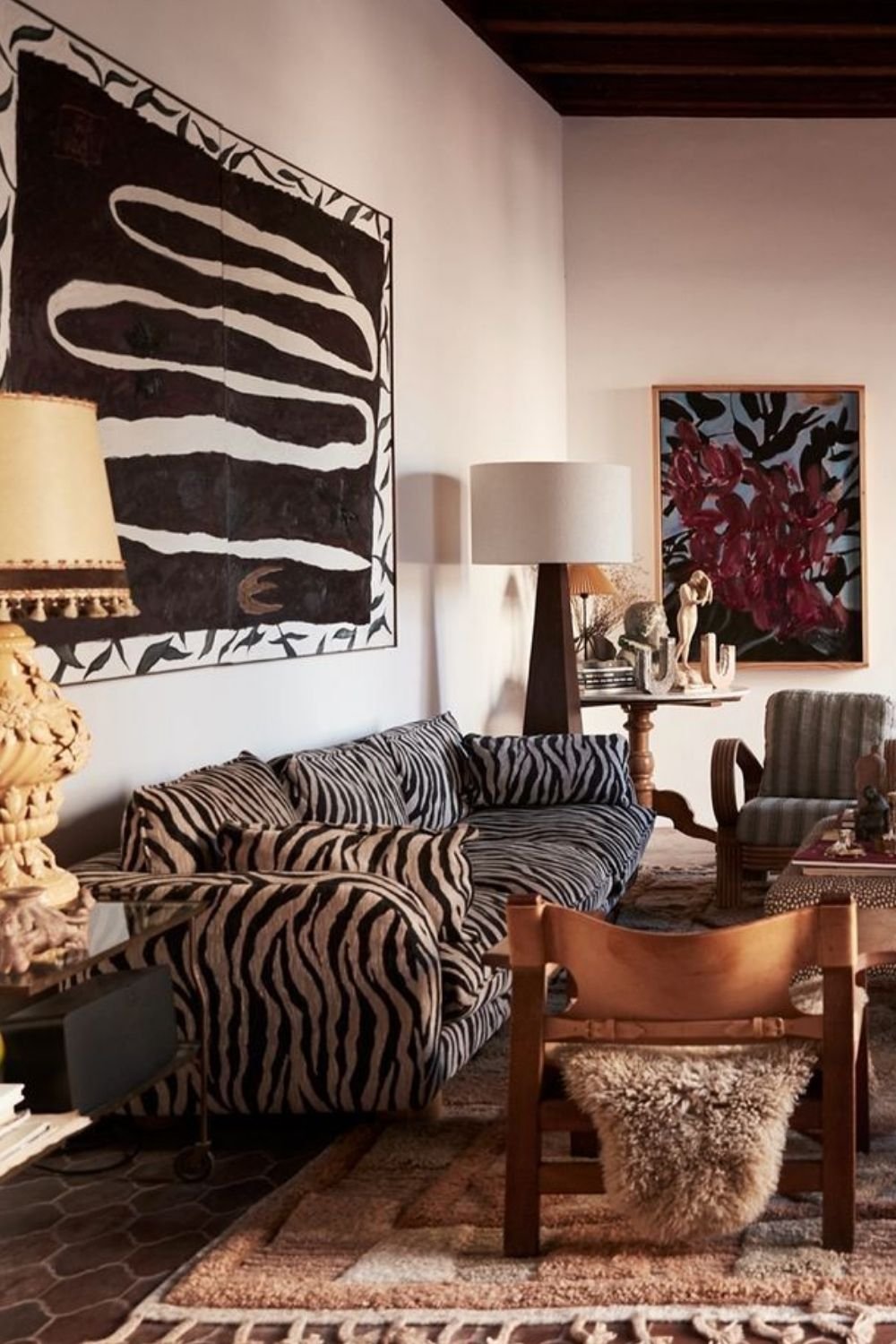 Eclectic living room with a zebra print sofa, large black and white abstract canvas and layered Amazigh style rugs
